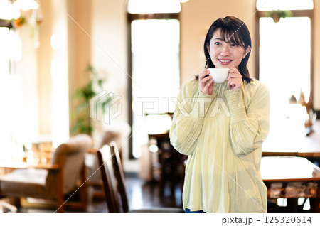コーヒーカップを持つ笑顔の女性 コーヒーカップを持つ笑顔の女性 125320614