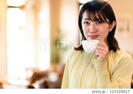 コーヒーカップを持つ笑顔の女性 コーヒーカップを持つ笑顔の女性 125320617
