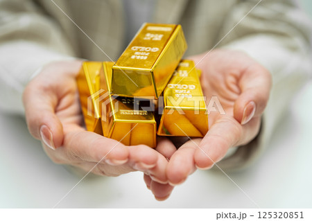 Asian woman holding gold bar in finance business. 125320851