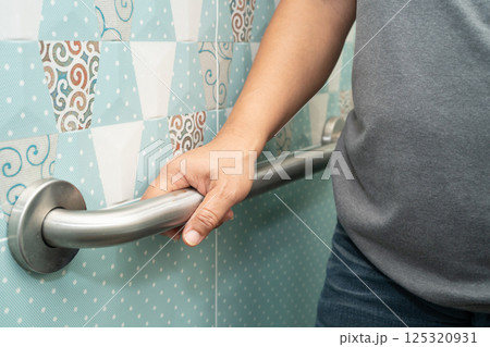 Asian elderly woman patient use handrail safety in toilet support rail in bathroom. Asian elderly woman patient use handrail safety in toilet support rail in bathroom. 125320931