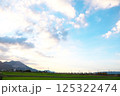 夕暮れの空の下、田園を走る貨物列車 125322474