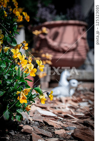白い鳥の置き物と黄色い花 125323085