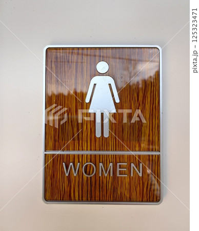 women restroom sign with wooden design displayed in public building. women restroom sign with wooden design displayed in public building. 125323471