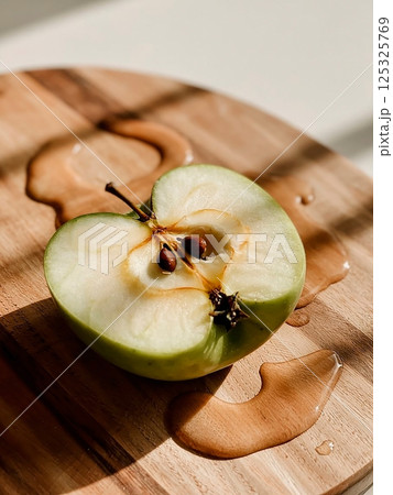 sliced green apple in drops of water on a white plate 125325769