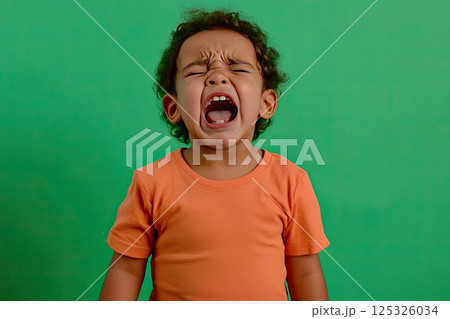 portrait of a crying child on a green background portrait of a crying child on a green background 125326034