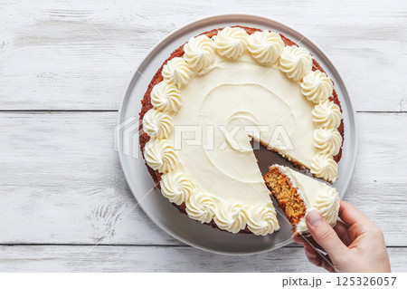 Homemade carrot cake with cheese cream topping on white wooden table. Top view 125326057