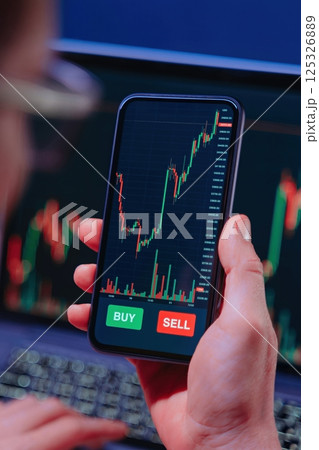 Man Analyzing Crypto Market Charts on Phone Man Analyzing Crypto Market Charts on Phone 125326889