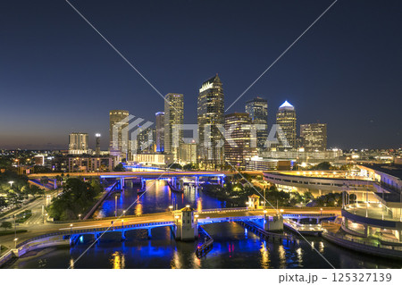 Tampa, Florida. Downtown district of American city after sunset with brightly illuminated high buildings and highway bridge traffic. USA travel destination. 125327139