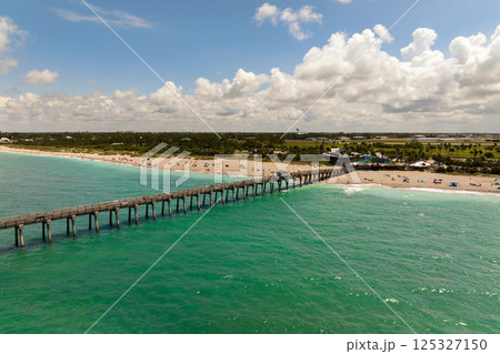 Summer landscape at Venice fishing pier in Florida. Ocean surf waves crashing on warm sandy beach Summer landscape at Venice fishing pier in Florida. Ocean surf waves crashing on warm sandy beach 125327150