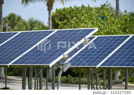 Solar panels installed on stand frame near parking lot for effective generation of clean electricity. Photovoltaic technology integrated in urban infrastructure for electric car charging Solar panels installed on stand frame near parking lot for effective generation of clean electricity. Photovoltaic technology integrated in urban infrastructure for electric car charging 125327199