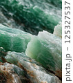 Green jade mineral close-up with natural crystal texture and layers. Studio lighting photography. Gemstone and geology concept. Design for print, poster, banner, wallpaper. Macro shot 125327537