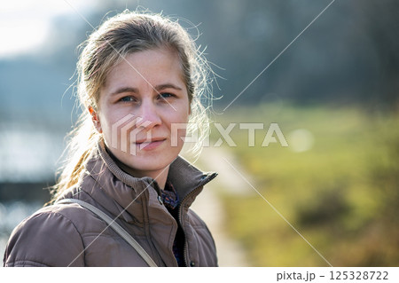 Portrait of young attractive woman enjoying warm sunny day in early spring outdoors. Portrait of young attractive woman enjoying warm sunny day in early spring outdoors. 125328722