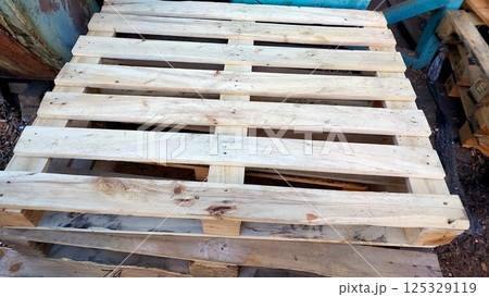 Wooden pallet resting on a stack at a construction site during daylight hours Wooden pallet resting on a stack at a construction site during daylight hours 125329119