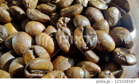 Dark roasted coffee beans ready for brewing in a rustic setting 125329167
