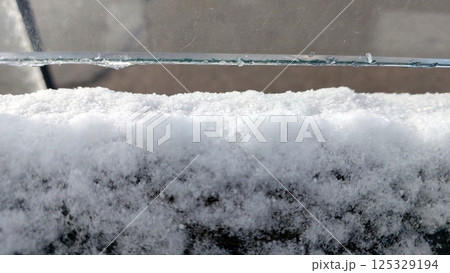 Snow-covered glass revealing a tranquil winter landscape in a quiet neighborhood 125329194