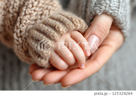 Tender moment of mother and baby hands together 125329264