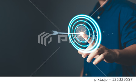 glow arrow hitting the center of a target symbolizes focus, purpose, mission, and the determination to achieve goal, highlighting precision, strategy, and success in personal or professional pursuits. 125329557