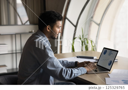Busy manager analyzes dynamic market trends using AI application 125329765
