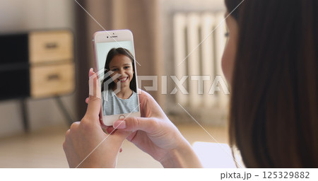 Cute girl talking to mother using videocall app 125329882