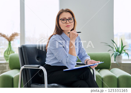 Portrait of professional psychologist therapist woman with clipboard in office Portrait of professional psychologist therapist woman with clipboard in office 125331165