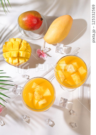 Frozen lemonade cocktail or juice with mango slices, mojito with tequila, lemon, ice, bar and party concept, restaurant and cafe advertising card, top view, selective focus. 125332569