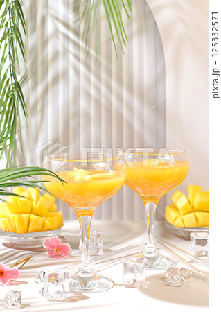 Frozen lemonade cocktail, margarita with mango slices, tequila, vodka, ice, bar and party concept, restaurant and cafe advertising card, top view, selective focus. Frozen lemonade cocktail, margarita with mango slices, tequila, vodka, ice, bar and party concept, restaurant and cafe advertising card, top view, selective focus. 125332571