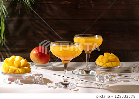 Summer party concept. Frozen lemonade cocktail, margarita with mango slices, tequila, vodka, ice, bar and leisure concept, restaurant and cafe advertising card, top view, 125332579