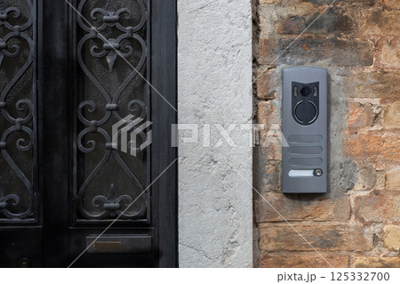Modern Intercom Panel on Brick Wall 125332700