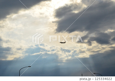雲の合間を縫って着陸する旅客機 125334022