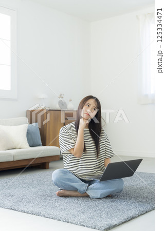 部屋でパソコンを見る女性　  125334471