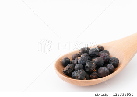 木のスプーンに載せたジュニパーベリーのクローズアップ 125335950