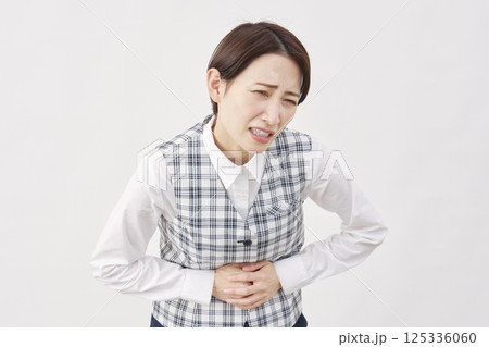 女性　事務員　腹痛　白背景 125336060