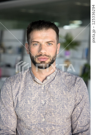 Vertical portrait of young and ambitious businessman posing in office Vertical portrait of young and ambitious businessman posing in office 125336294