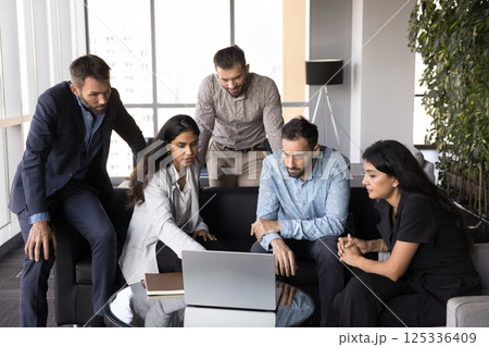 Multiethnic teammates discussing online presentation using laptop 125336409