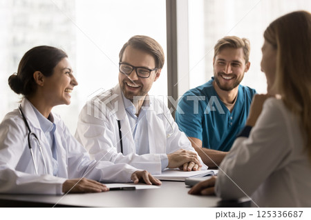 Young diverse polyethnic engaged in joyful conversation after hospital shift Young diverse polyethnic engaged in joyful conversation after hospital shift 125336687