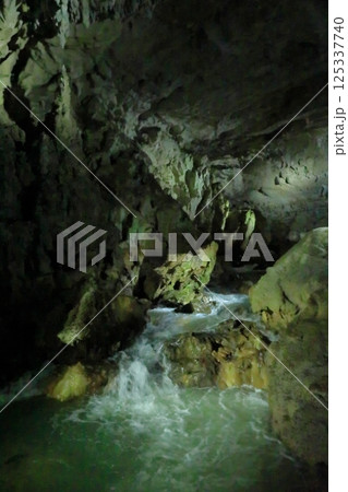 秋芳洞の洞窟内を流れ落ちる川の景色 125337740