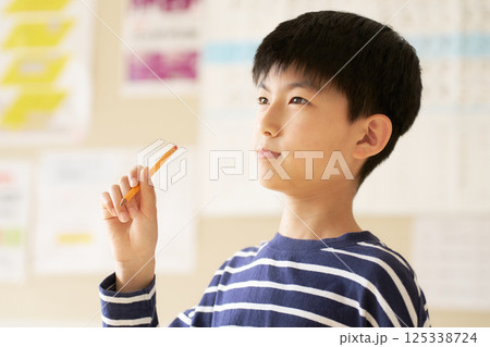 鉛筆を片手に考える小学生 125338724