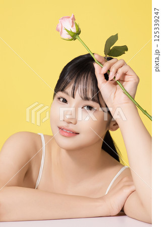 Portrait of a young woman holding a flower Portrait of a young woman holding a flower 125339247