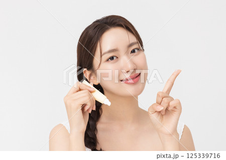 Cropped view of young woman posing with lip balm 125339716