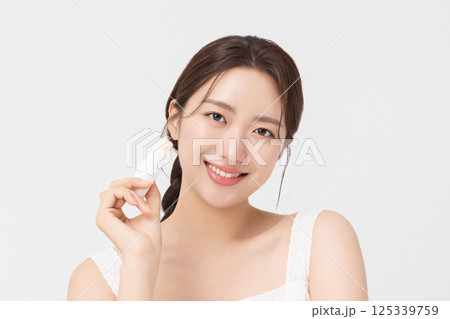 Cropped view of young woman posing with lip balm 125339759