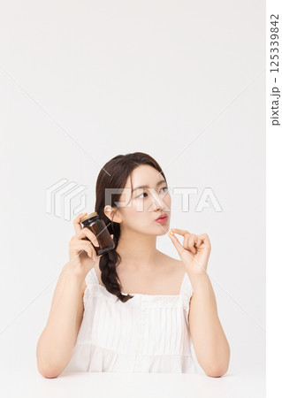 A young woman taking nutritional supplements for her health A young woman taking nutritional supplements for her health 125339842