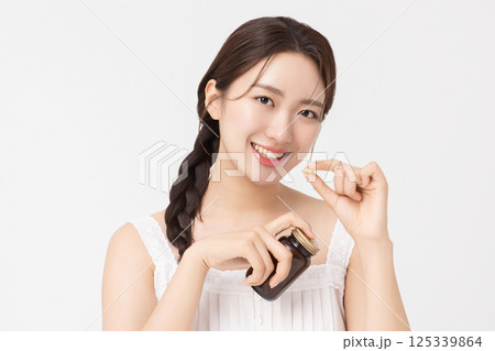 A young woman taking nutritional supplements for her health A young woman taking nutritional supplements for her health 125339864