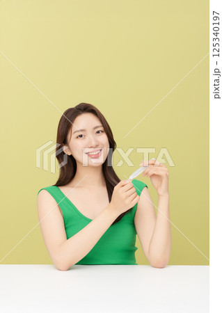 Portrait of young woman taking care of her nails 125340197