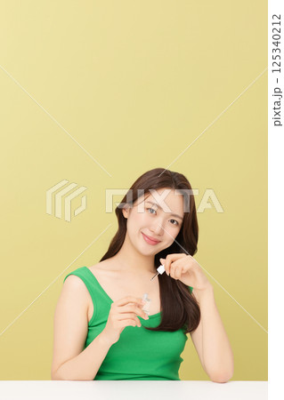 Portrait of young woman taking care of her nails 125340212