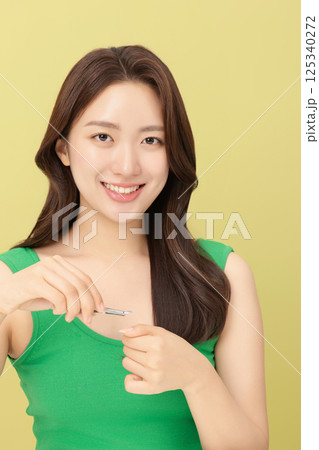 Cropped view of young woman taking care of her nails with nail clippers 125340272