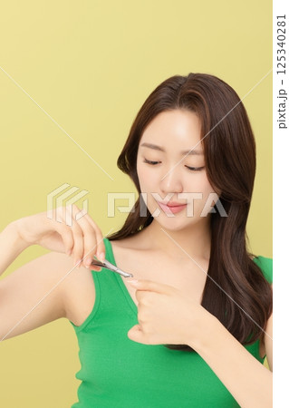Cropped view of young woman taking care of her nails with nail clippers Cropped view of young woman taking care of her nails with nail clippers 125340281