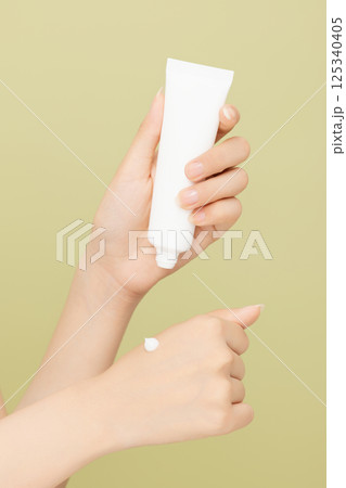 Woman's hands applying hand cream 125340405