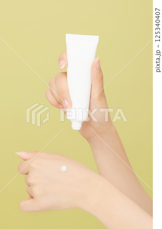Woman's hands applying hand cream 125340407