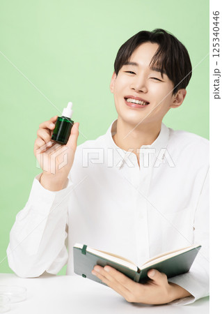 A young man posing with basic cosmetics made using plants A young man posing with basic cosmetics made using plants 125340446