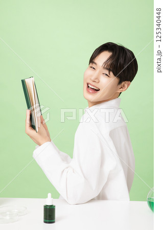 A young man posing with basic cosmetics made using plants 125340448